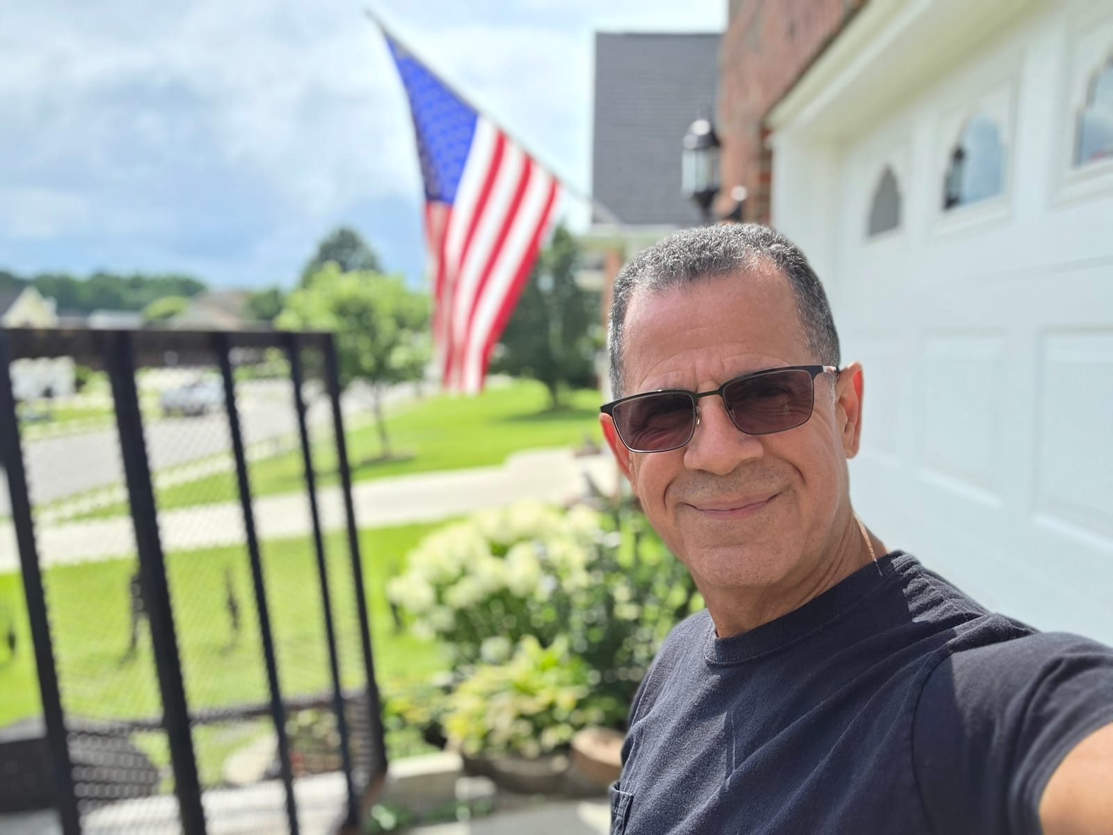 George Hinestrosa at home, beside the American flag